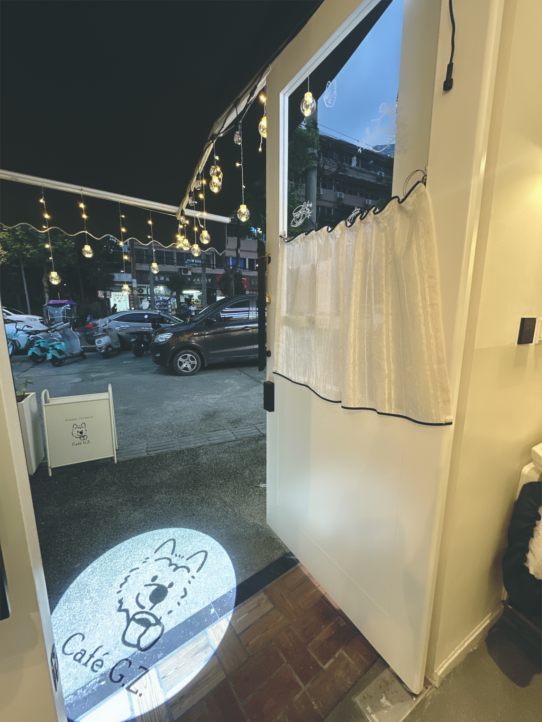 The café doorway and dog-logo light projection